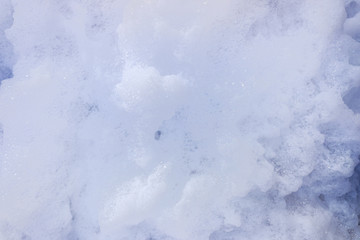 Remains of soap foam, bubbles and water scattered on the ground.