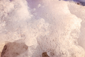 Remains of soap foam, bubbles and water scattered on the ground.