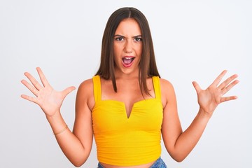 Fototapeta premium Young beautiful girl wearing yellow casual t-shirt standing over isolated white background celebrating crazy and amazed for success with arms raised and open eyes screaming excited. Winner concept