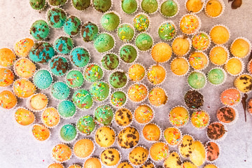 Tray with small muffins with colored topping.