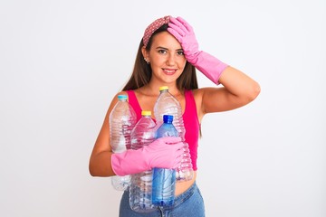 Beautiful girl wearing cleaner gloves recycling plastic bottles over isolated white background stressed with hand on head, shocked with shame and surprise face, angry and frustrated. Fear