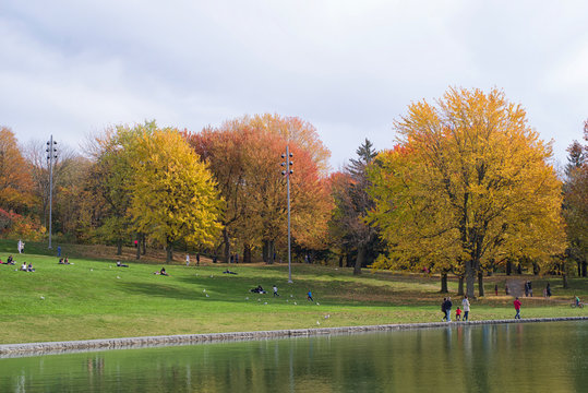 People enjoy a warm autumn day at the Beaver Lake in Mont Royal Park, Montreal