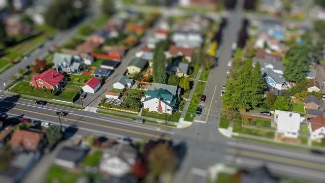 Circular hyperlapse footage of an aerial view fly-over of an American suburban neighborhood; tilt-shift lens effect
