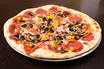 Pizza with pepperoni and mushrooms, ham and sweet pepper. Close-up.