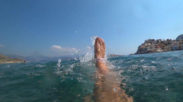Kastellorizo, Greek island - 1st of October 2019: 4K Paddling feet and a child in water