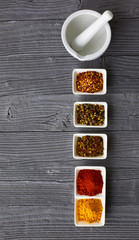 Various spices in a bowls on gray background