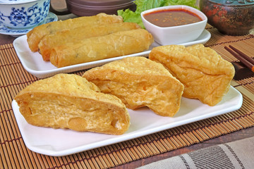 Fried Tofu and Deep fried crispy Spring rolls, served with sweet and spicy chili sauce. Vegetarian food for Vegetarian festival. Selective focus