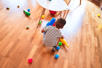 Beautiful toddler boy playing bowling at kindergarten