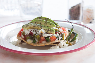 Tostada con verduras, queso y aguacate