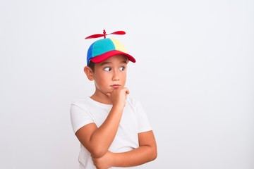 Beautiful kid boy wearing fanny colorful cap with propeller over isolated white background with...