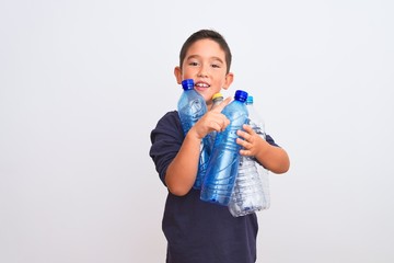 Beautiful kid boy recycling plastic bottles standing over isolated white background very happy...