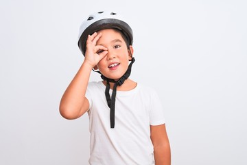 Beautiful kid boy wearing bike security helmet standing over isolated white background doing ok gesture with hand smiling, eye looking through fingers with happy face.