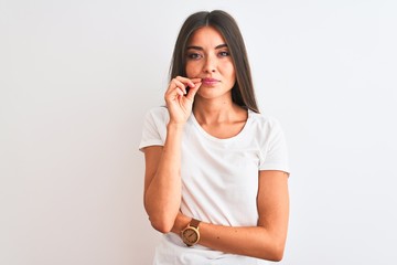 Young beautiful woman wearing casual t-shirt standing over isolated white background mouth and lips shut as zip with fingers. Secret and silent, taboo talking