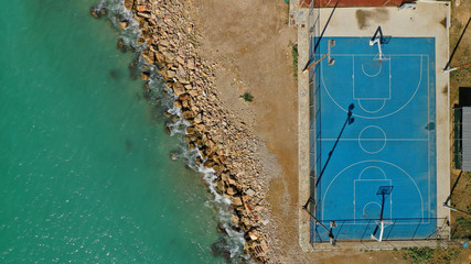 Aerial top down photo of outdoor basketball court by the sea in Piraeus area, Attica, Greece