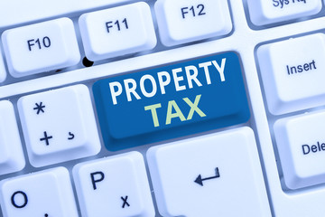 Conceptual hand writing showing Property Tax. Concept meaning an ad valorem tax on the value of a property Millage rate White pc keyboard with note paper above the white background