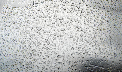Shiny, metallic background, covered with water drops. Texture of water on a metal surface.