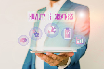 Conceptual hand writing showing Humility Is Greatness. Concept meaning being Humble is a Virtue not to Feel overly Superior Male human wear formal suit presenting using smart device