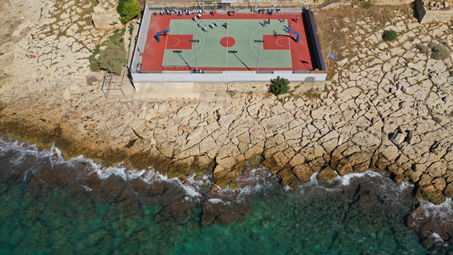 Aerial top down photo of outdoor basketball court by the sea in Piraeus area, Attica, Greece