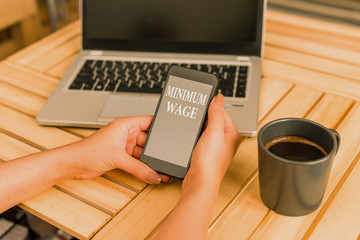 Writing note showing Minimum Wage. Business concept for the lowest wage permitted by law or by a...