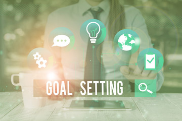 Fototapeta premium Handwriting text writing Goal Setting. Conceptual photo process of identifying something that you want to accomplish Female human wear formal work suit presenting presentation use smart device