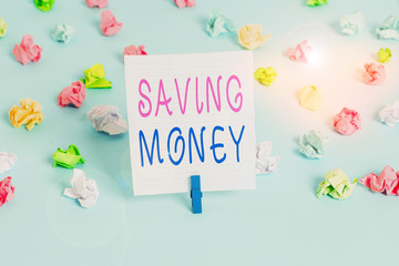 Conceptual hand writing showing Saving Money. Concept meaning putting money in an account in a bank o financial organization Colored crumpled papers empty reminder blue floor clothespin