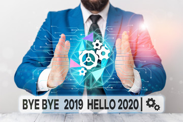 Text sign showing Bye Bye 2019 Hello 2020. Business photo showcasing Starting new year Motivational message 2019 is over Male human wear formal work suit presenting presentation using smart device © A