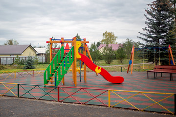 playground in the park swings, slides of a building of different colors for children's games