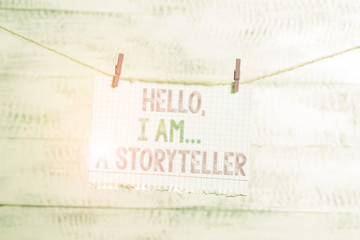 Writing note showing Hello I Am A Storyteller. Business concept for introducing yourself as novels article writer Clothesline clothespin rectangle shaped paper reminder white wood desk