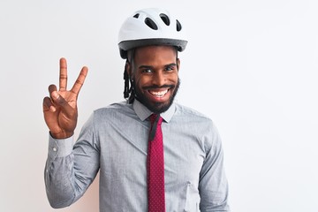 African american businessman with braids wearing bike helmet over isolated white background smiling with happy face winking at the camera doing victory sign. Number two.