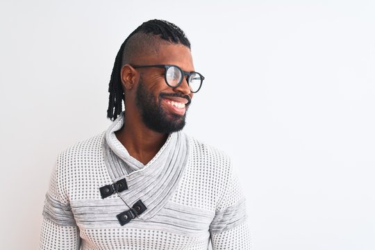 African american man wearing grey sweater and glasses over isolated white background looking away to side with smile on face, natural expression. Laughing confident.