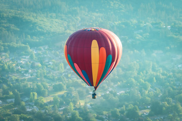 Colorful hot air balloon over Grants Pass Oregon on a beautiful summer morning