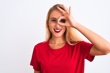Young beautiful woman wearing red casual t-shirt standing over isolated white background doing ok gesture with hand smiling, eye looking through fingers with happy face.
