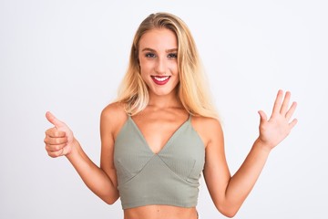 Young beautiful woman wearing casual green t-shirt standing over isolated white background showing and pointing up with fingers number six while smiling confident and happy.