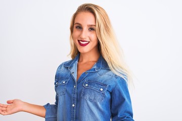 Young beautiful woman wearing casual denim shirt standing over isolated white background smiling cheerful with open arms as friendly welcome, positive and confident greetings