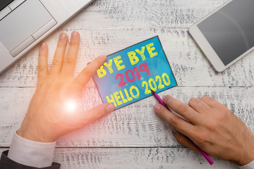 Writing note showing Bye Bye 2019 Hello 2020. Business concept for Starting new year Motivational message 2019 is over © Zofia