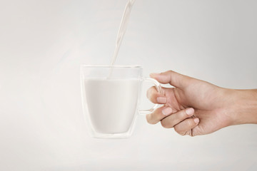 Man holding a glass of fresh milk on a white background