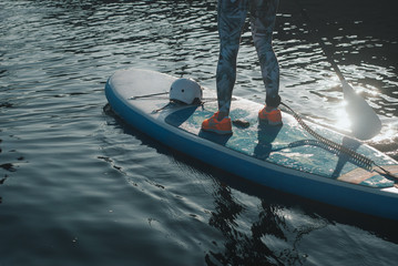 Obraz premium Sporty girl in bright sneakers on sup Board,