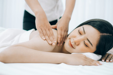 Fototapeta na wymiar Beautiful young woman lying down on beds massage and spa at asian spa massage and beauty salon center, spa concept, massage concept
