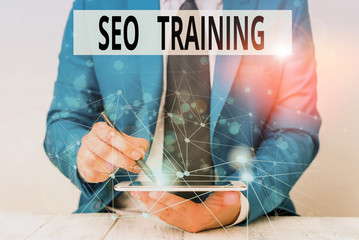 Text sign showing Seo Training. Business photo showcasing learn specific knowledge improve perforanalysisce in current roles Male human wear formal work suit presenting presentation using smart device