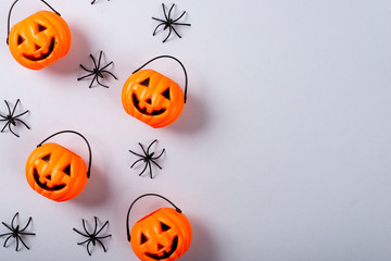 Halloween and decoration concept, Pumpkin with face and spiders on gray background.