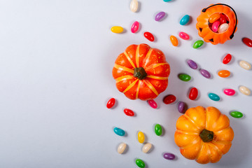 Halloween and decoration concept, Pumpkins and candies scattered on gray background.