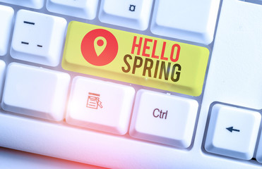 Text sign showing Hello Spring. Business photo showcasing welcoming the season of the blossoming of flowers End of winter White pc keyboard with empty note paper above white background key copy space