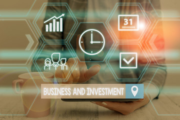 Fototapeta premium Word writing text Business And Investment. Business photo showcasing putting your money in field to increase them Woman wear formal work suit presenting presentation using smart device