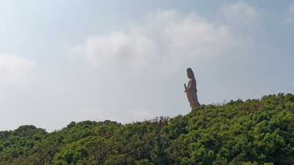 South Beach GuanYin 33 meters bronze statue with forest and sky background in Putuo mountain island, Zhejiang province, China.