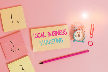 Writing note showing Local Business Marketing. Business concept for Localized specification on Store characteristic Blank notepads marker rubber band alarm clock clip colored background