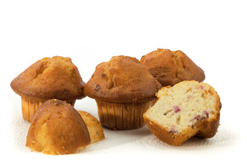 a group of golden lemon cranberry muffins and a cut muffin isolated on white