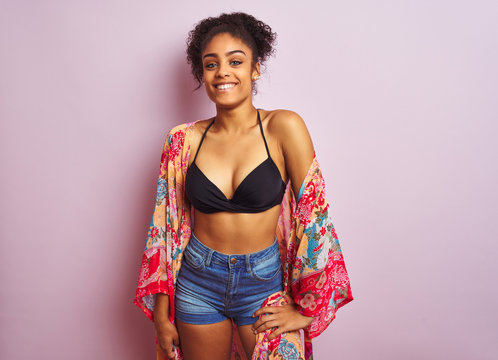 Young beautiful african american woman on vacation standing wearing bikini and colorful caftan