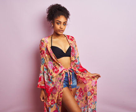 Young beautiful african american woman on vacation standing wearing bikini and colorful caftan