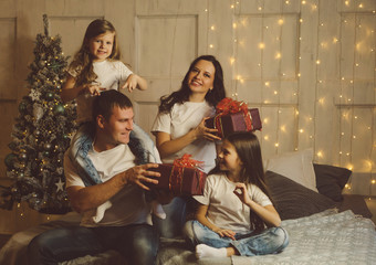 Gifts time! Christmas morning. Friendly fashionable family. Light living room at home with...