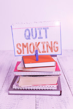 Text sign showing Quit Smoking. Business photo text process of discontinuing tobacco smoking or cessation pile stacked books notebook pin clothespin colored reminder white wooden